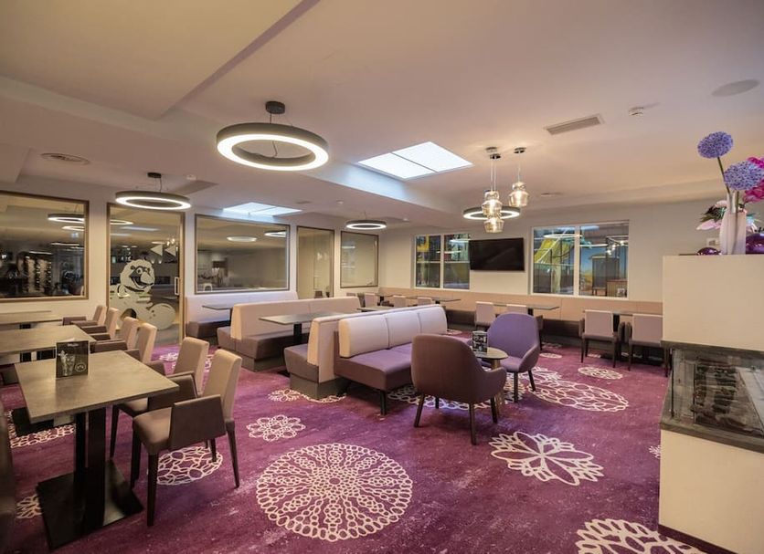 Thermenhotel Kurz in Lutzmannsburg lounge with dining tables, sofas, purple carpet and modern ceiling lights
