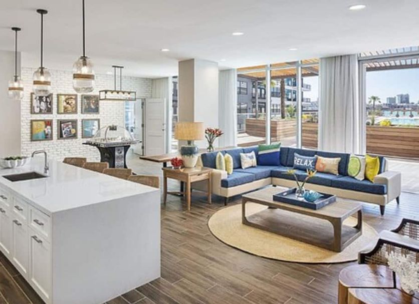 Margaritaville Hotel Nashville living room with blue sectional, kitchen island and balcony view in Nashville