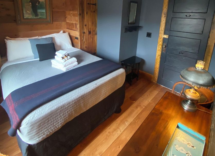 Crew's Quarters Boarding House - Caters to Men room with bed, wooden floors and nautical decor in Provincetown