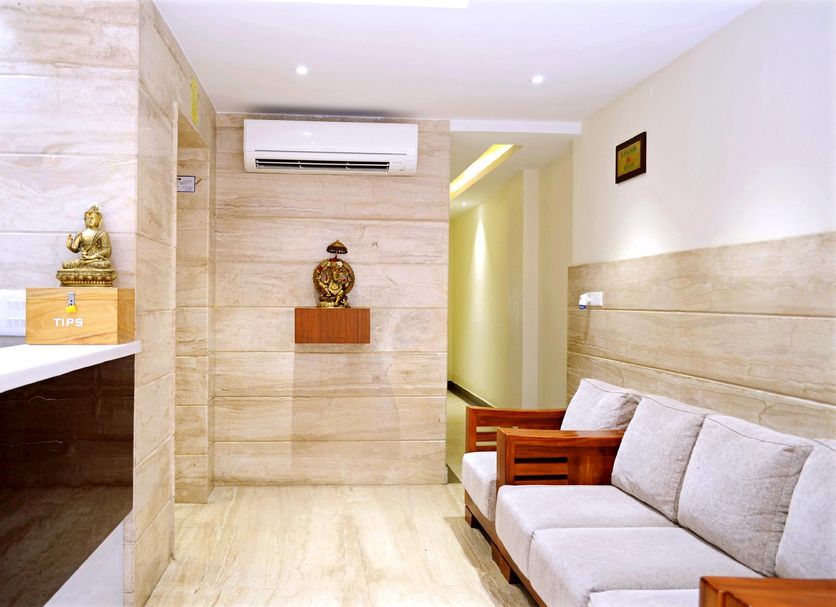 TR Residency Pondicherry lobby with sofa seating, wall art, and air conditioner in a bright hallway