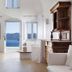 Villaki Oia in Oia with airy white interiors, arched windows, and a sea-view opening to blue water