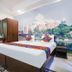 Hotel Taj Heritage, Agra: bed with Taj Mahal wall mural, wardrobe, mirror, and chair in guest room