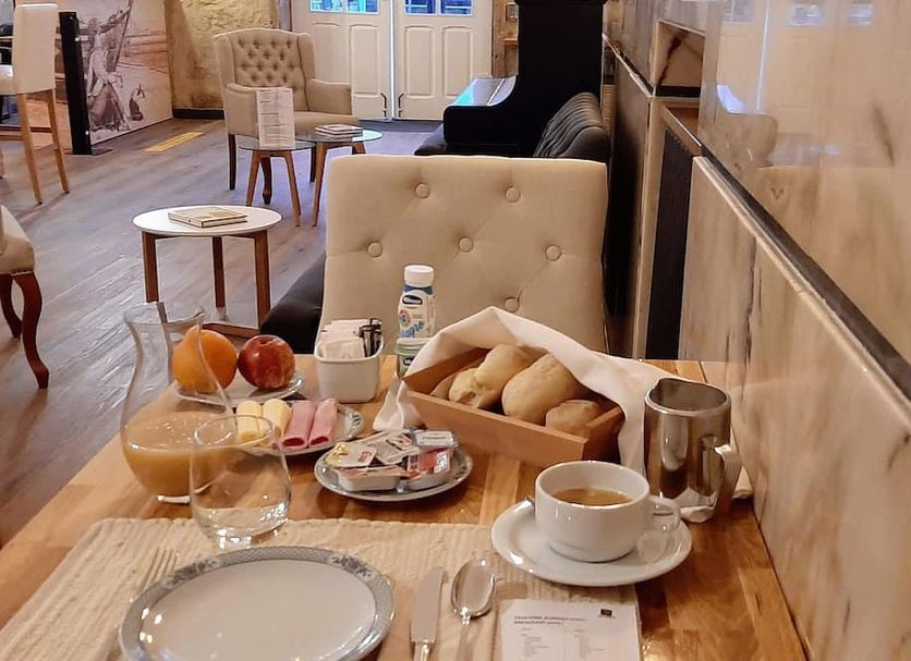 Breakfast table at Hotel Poveira in Porto with coffee, juice, pastries and bread basket