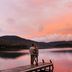 Lake Placid Lodge in Lake Placid: couple standing on a dock beside a calm lake at sunset