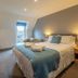 Winchelsea Lodge bedroom in Winchelsea with a double bed, bedside lamps, and a small window