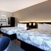 Studio 6 Pensacola, FL - West I-10 room with two double beds and blue chairs