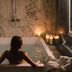 Hotel The Haven Roma in Rome: guest relaxing in a marble bathroom tub with candles and city view