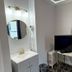 Twin Peaks Hotel San Francisco bathroom vanity with round mirror, TV and small desk