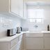 Central Cozy Apartments in Plaka by Upst kitchen in Athens with sink, white cabinets, and countertop appliances
