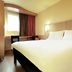 Ibis Lille Lomme Centre guest room with large bed, desk, window and curtains in Lomme