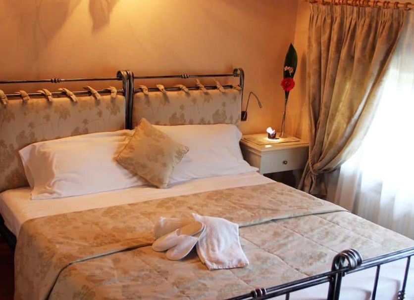 La Perla del Sile Country House in Silea: cozy double bed with bedside table and sheer-curtained window