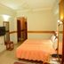 Hotel City Tower Coimbatore guest room with bed, wall-mounted TV, and ceiling fan