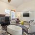 Best Western Porterville Inn lounge with fireplace, wall TV, striped chairs and ottoman in Porterville