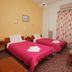Evans Hotel Heraklion twin room with two single beds, bedside tables, and curtains