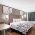 Red Roof Inn Richmond - Airport Sandston guest room with king bed, wood floor, desk, and window curtains