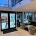 The Harrison Hotel Downtown Hollywood FL lobby with seating, glass doors, and an outdoor courtyard view in Hollywood
