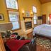 Elliott House Boutique Inn Shaver Lake guest room with king bed, fireplace, and tall windows