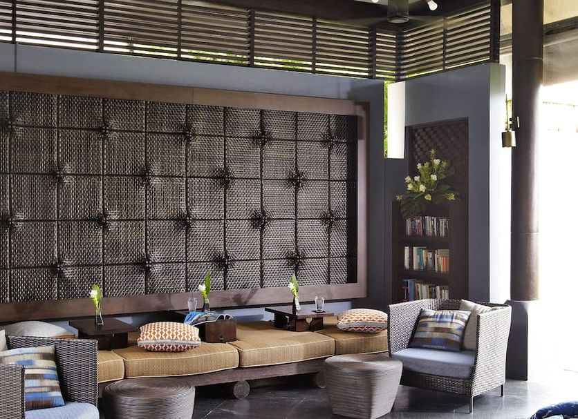 Sareeraya Villas & Suites, Ko Samui: stylish lounge with cushioned seating and decorative wall panel