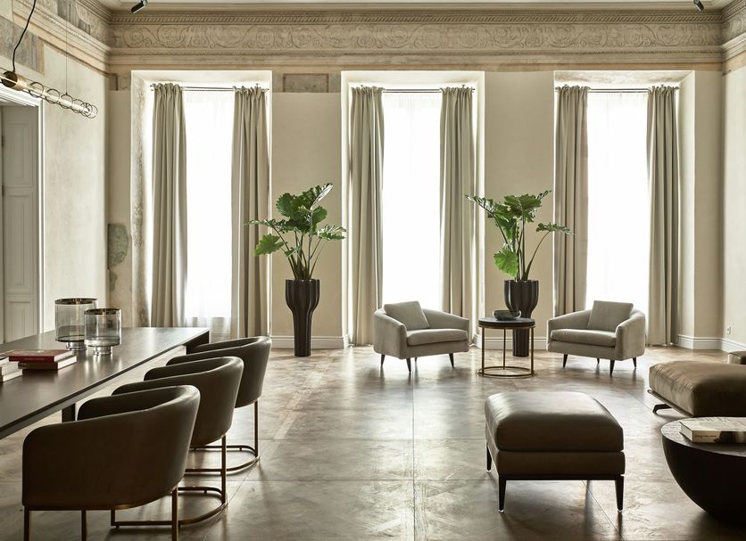 Hotel Pacai in Vilnius lounge with tall windows, beige curtains, armchairs and potted plants