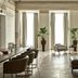 Hotel Pacai in Vilnius lounge with tall windows, beige curtains, armchairs and potted plants