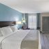 SureStay Plus by Best Western Asheboro guest room with king bed, desk, TV, chair and window light
