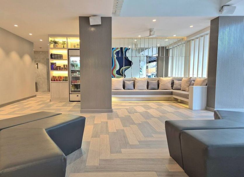 The Bloc Hotel in Patong lobby lounge with seating, bar display, and mirrored wall