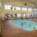 Santa's Lodge indoor pool in Santa Claus with swimmers, lounge chairs, and high windows