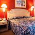 Scottish Inn Downtown Jacksonville room with floral bedspread, twin lamps and red walls in Jacksonville