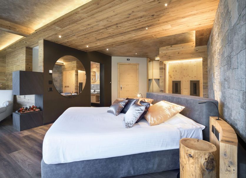 Hotel Lac Salin Spa & Mountain Resort in Livigno, rustic modern bedroom with wood ceiling and mountain decor