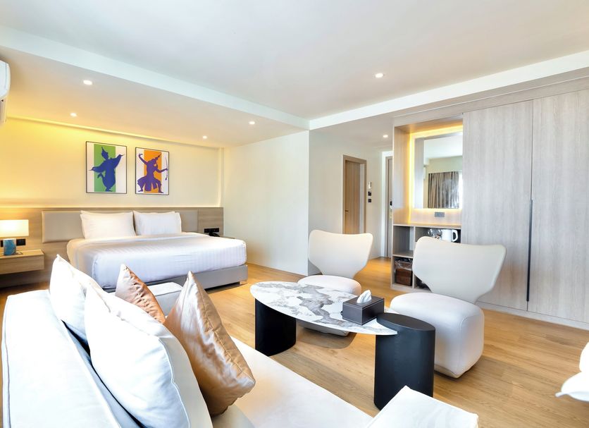 The One Hotel Bay Breeze Pattaya guest room with king bed, seating area and balcony-style view of Pattaya
