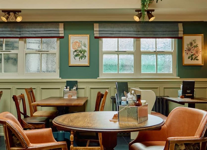 The Pennine Inn, Kirkby Stephen dining room with round table, leather chairs and windows
