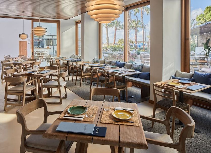 Hotel Tres Torres in Santa Eulària des Riu dining room with large windows and marina views