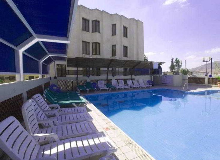 C Hotel Tiberias pool deck with lounge chairs, shaded seating and mountain views