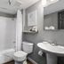 The Oxford at Pike Place Market bathroom with tub-shower, toilet, pedestal sink and wall mirror in Seattle