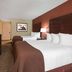 Baymont by Wyndham Midland Airport guest room with two queen beds and TV in Midland