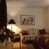 The Garden Walk Bed & Breakfast in Lookout Mountain bedroom with striped loveseat, lamp, and floral bedspread