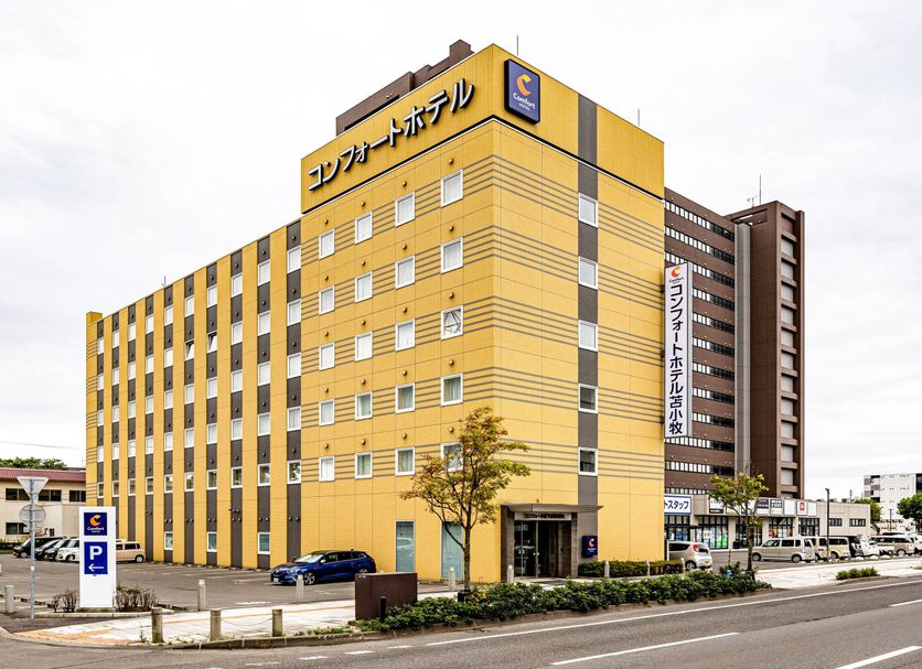 Comfort Hotel Tomakomai in Tomakomai, yellow mid-rise hotel exterior with parking lot