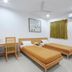 Hotel De Ecobiz Ahmedabad twin-bed guest room with desk and window curtain