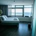 De Pier Suites, The Hague: oceanview suite with king bed beside large windows overlooking the sea