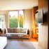 Hotel Arima & Spa in San Sebastian guest room with sofa, large window, and TV