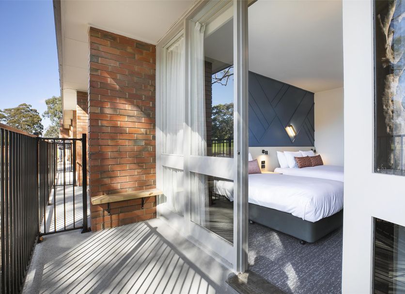 Nightcap at Sandown Park Hotel in Noble Park balcony view into bedroom with bed and sliding glass door
