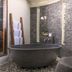 The Purist Villas & Spa Ubud bathroom with stone soaking tub, pebble floor, and spa-style vanity in Ubud