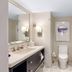 The H Hotel Midland bathroom with double vanity, toilet, and glass shower enclosure