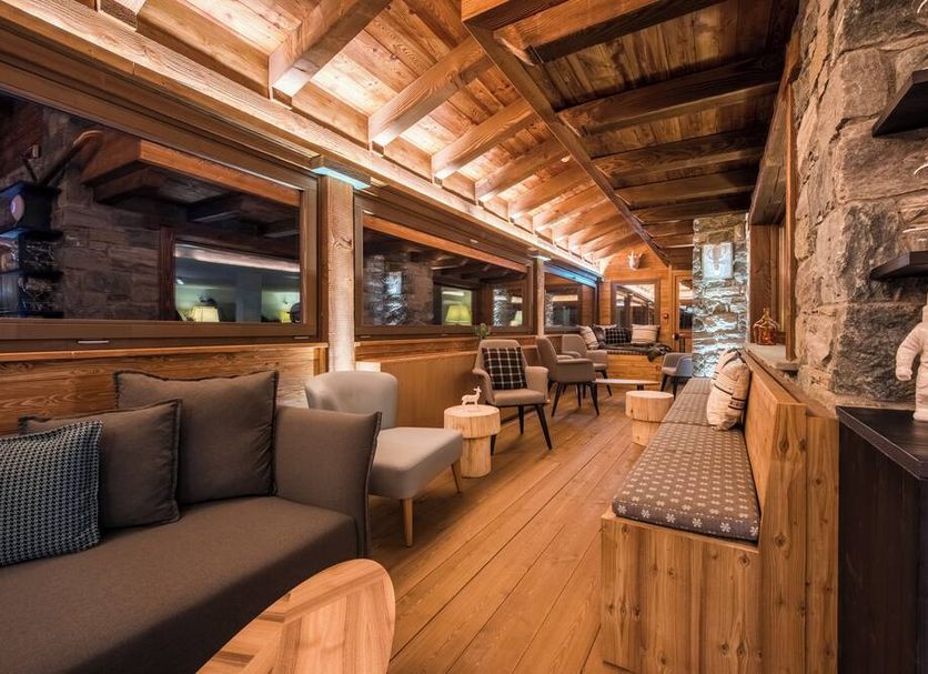 Hotel Principe Delle Nevi lounge in Breuil-Cervinia with wood-paneled interior and stone fireplace