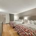 Red Roof Inn Kingsport room with two queen beds, wood flooring, and wall-mounted TV