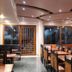Hotel Aroma Classic Jaipur dining room with wooden tables, carved chairs, and large windows
