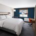 Holiday Inn Express & Suites Drums-Hazleton room with king bed, desk, and colorful wall art