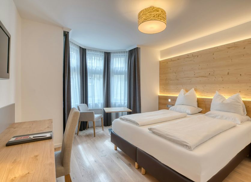 Hotel Leipziger Hof Innsbruck guest room with twin beds, desk and large windows
