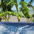 Come Friday Cottages on the Bay hot tub with tropical plants and bay view in Bacliff