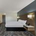 Econo Lodge Cherry Point in Havelock room with king bed, wall-mounted TV, and compact fridge